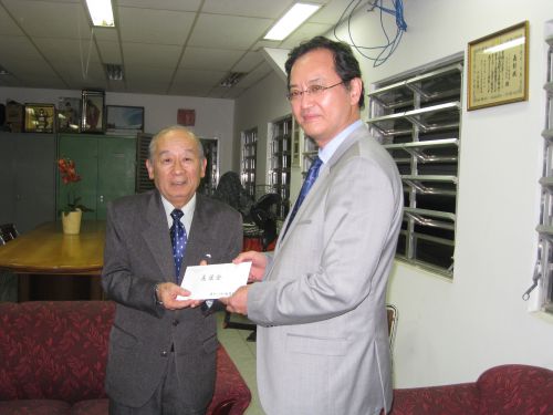 田呂丸会長（左）に義援金を渡す中前総領事