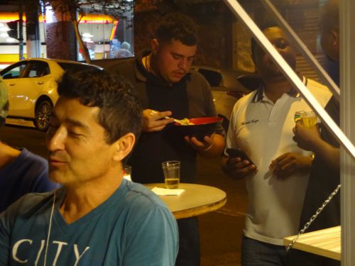 フードトラックのラーメン屋『ラーメンＫ』でラーメンを立ち食いする人々