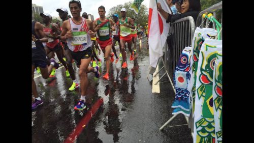 日の丸とこいのぼりでマラソン選手を応援する日本人