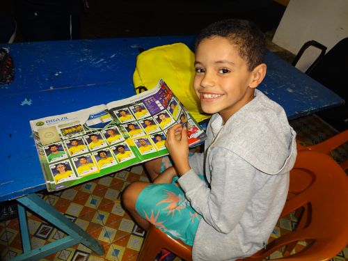 FIFAワールドカップ向けのステッカーアルバムを作るブラジルの少年