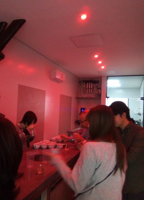 赤いランプの下でコーヒー鑑定を体験中