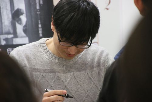 サイン会でペンを走らせる東山彰良氏