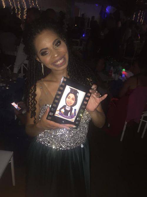 学校の卒業式で似顔絵の記念品を受け取るブラジル人女性